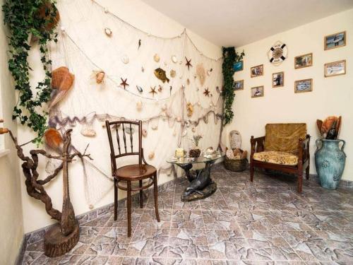 a living room with chairs and a wall with shells at Holiday Home By The Sea - Nina & Kate in Ston