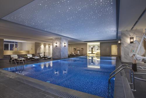 una piscina de hotel con techo de estrellas en Somerset Grand Central Dalian, en Dalian