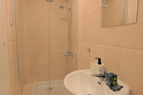 uma casa de banho com um lavatório e um chuveiro em Phaedrus Living: City Flat Palas 103 em Pafos