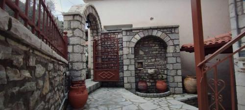 an entrance to a building with a door and some vases at Ξενώνας Ερυκίνη in Dhímitra