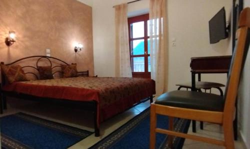 a bedroom with a bed and a chair and a piano at Ξενώνας Ερυκίνη in Dhímitra