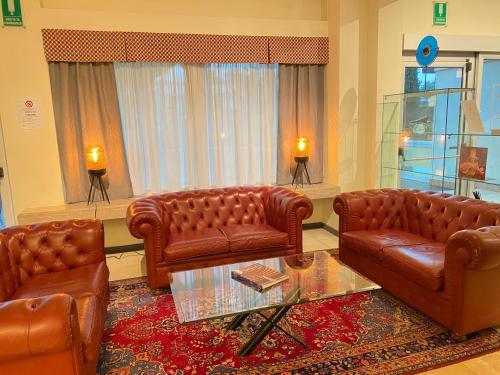 a living room with two leather couches and a table at Hotel Estée in Desenzano del Garda