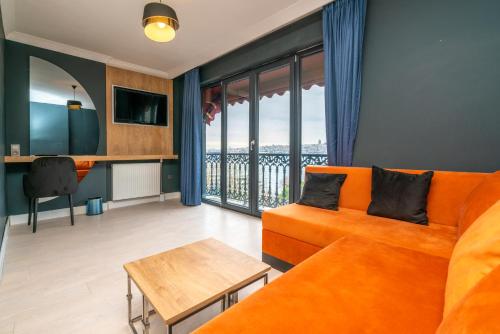 uma sala de estar com um sofá laranja e uma mesa em 216 Bosphorus Suite em Istambul