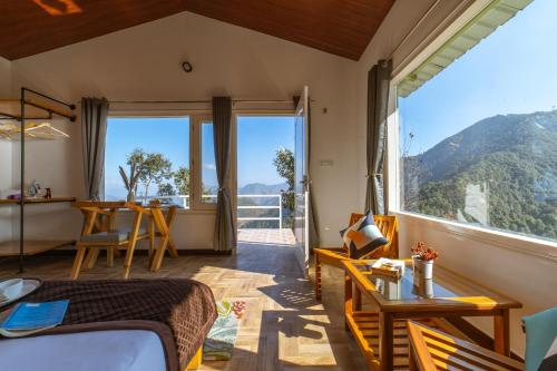a bedroom with a bed and a large window at Zostel Plus Nainital (Naina Range) in Nainital