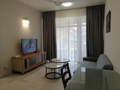 a living room with a couch and a tv and a table at City Tropical Home I in George Town