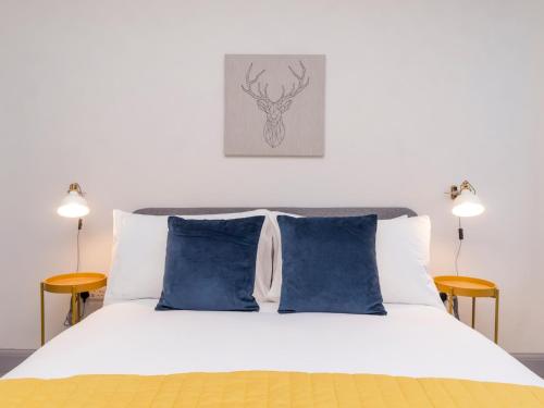 1 dormitorio con cama blanca y almohadas azules en Pass the Keys Stunning 2 bed retreat in the heart of Bath, en Bath