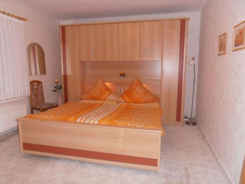 a bedroom with a large bed with a wooden headboard at Ferienhaus Müller in Benneckenstein