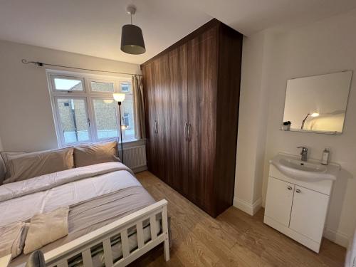 a bedroom with a bed and a sink at 4 Wharncliffe Drive in Hanwell