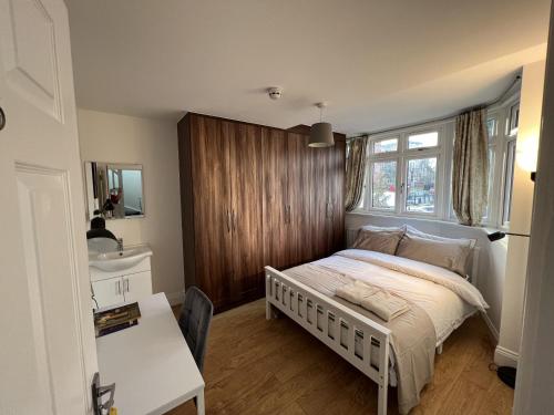 a bedroom with a bed and a desk and a window at 4 Wharncliffe Drive in Hanwell