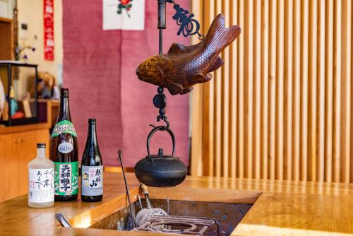 a fish head hanging over a kitchen sink with wine bottles at Bandai in Tokamachi