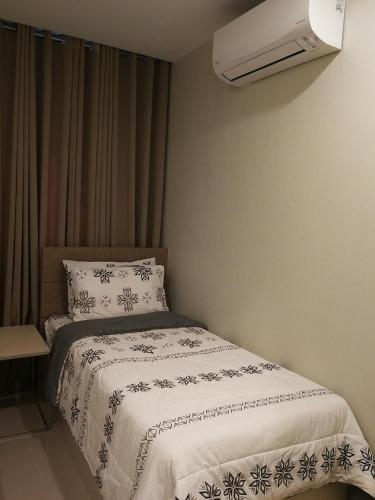 a bedroom with a bed with a white comforter at Adria Residences - Ruby Garden - 2 Bedroom for 4 person in Manila