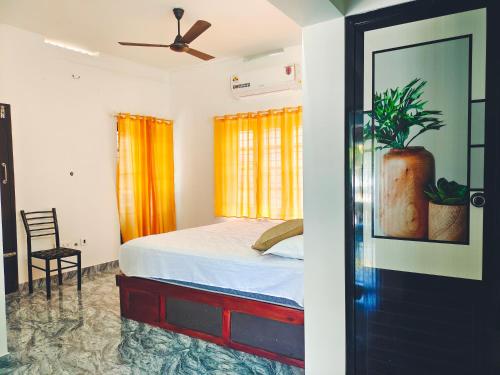 1 dormitorio con 1 cama y ventilador de techo en MALHAR MARARI HOMESTAY, en Mararikulam