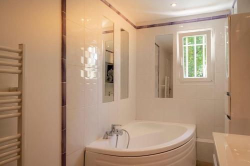 a white bathroom with a toilet and a sink at Villa Rhéa in Roquebrune-sur-Argens