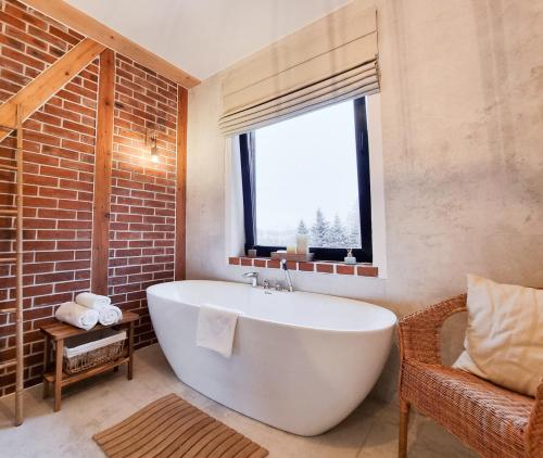 een badkamer met een groot wit bad en een raam bij Sporthaus Sosnówka - Villa Deluxe in Sosnówka