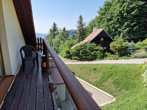 a wooden deck with a chair and a barn at Wellness hotel Chata Jana in Lopeník
