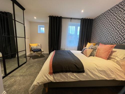 a bedroom with a large bed and a chair at Modern 2 Bedroom Aesthetic Apt in Manchester