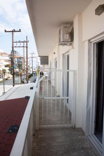 a white building with a fence next to a street at ELENI in Paralia Katerinis