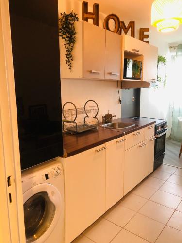 a kitchen with a washing machine in a kitchen at Suite Cosy Home Evry Paris in Évry-les-Châteaux