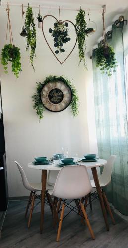 a dining room table with chairs and a clock on the wall at Suite Cosy Home Evry Paris in Évry-les-Châteaux