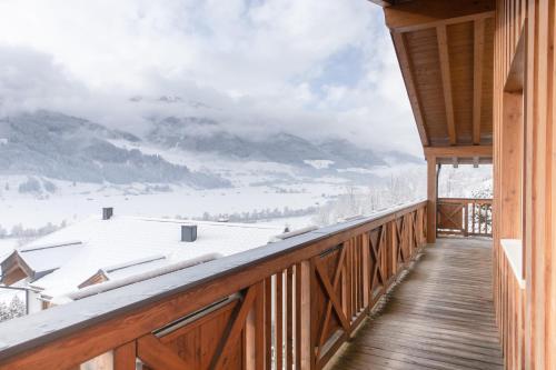 a balcony with a view of a snow covered mountain at AvenidA Panorama Chalet by Alpin Rentals in Piesendorf