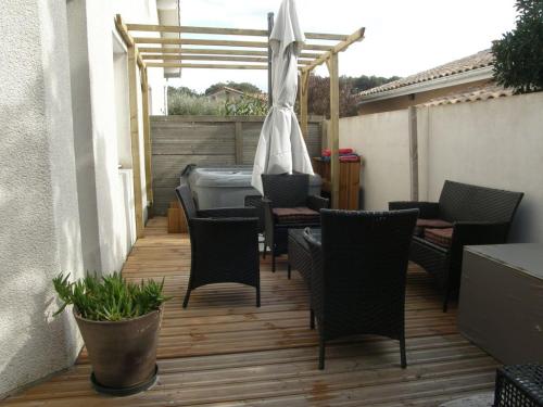 un patio avec une table, des chaises et un parasol dans l'établissement KIKINE, à Biscarrosse