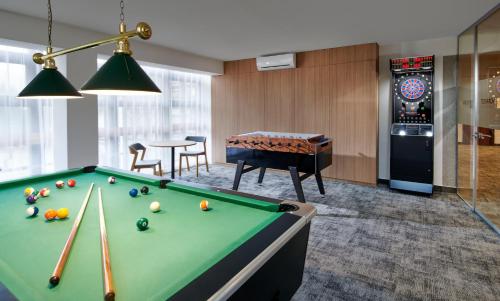 a room with a pool table in a room with a table at Wellness Hotel Svornost in Harrachov