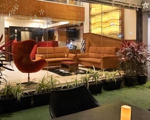a lobby with a couch and chairs and plants at Quality Inn Mint in Pune
