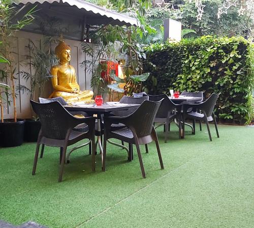 a table and chairs with a statue of a buddha at Quality Inn Mint in Pune