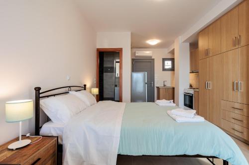 sypialnia z dużym łóżkiem i kuchnią w obiekcie Georgia seaview apartment B3 w Kalamácie
