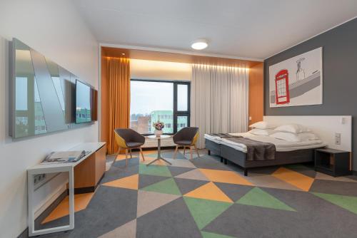 Hotel Sophia by Tartuhotels في تارتو: غرفة نوم بسرير وطاولة وكراسي