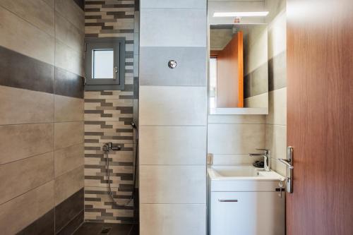 łazienka z umywalką, toaletą i lustrem w obiekcie Georgia seaview apartment B3 w Kalamácie