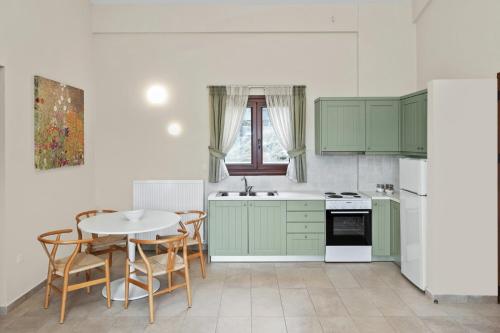 una cucina con armadi verdi, tavolo e sedie di Aria Monte Villas a Raches