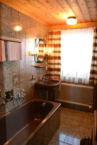 een badkamer met een groot bad en een wastafel bij Landhaus Buchsteiner in Forstau