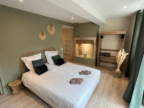 a bedroom with a large white bed with two towels on it at Suite cosy au cœur de Vinzelles proche Mâcon Tout équipé avec salon d'extérieur in Vinzelles