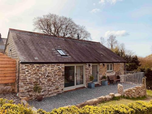 a small brick house with a patio at Detached Barn in Tamar Valley, EV charging included in Yelverton