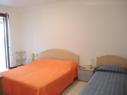 1 dormitorio con 1 cama naranja y 1 cama azul sidx sidx sidx sidx en Amazing apartment with terrace for 5 guests, en Bibione