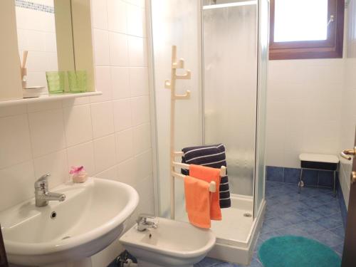 y baño con lavabo, ducha y aseo. en Amazing apartment with terrace for 5 guests, en Bibione