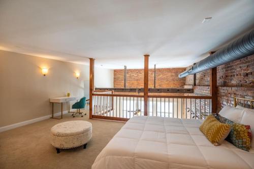 a bedroom with a large bed and a brick wall at Ultra Chic Loft sleeps 4 in Fayetteville