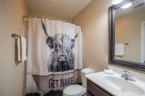 a bathroom with a shower curtain with a cow on it at Ultra Chic Loft sleeps 4 in Fayetteville