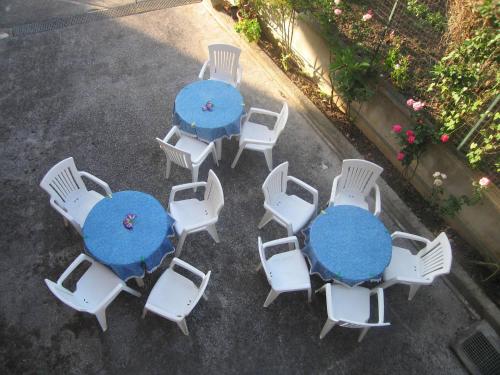 eine Gruppe von Tischen mit weißen Stühlen und blau in der Unterkunft Room in Apartment - 15min Da Tropea Monolocale Vista Mare A Briatico in Briatico