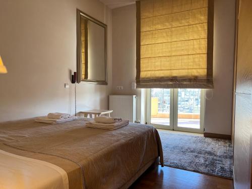 a bedroom with a bed and a large window at Marousi Luxury Apartment in Athens