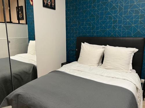 une chambre avec deux lits et un mur bleu dans l'établissement Appartement Thida, à Paris