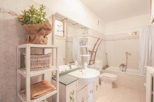 uma casa de banho branca com um lavatório e um WC em Casa Rosa di Luisa em Menaggio
