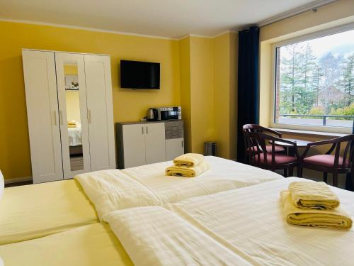 a bedroom with two beds with towels on them at M&M Hotel - Neu Wulmstorf in Neu Wulmstorf