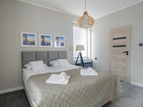 a bedroom with a bed with two towels on it at Stylove Apartamenty in Ustrzyki Dolne