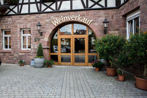 - l'entrée d'un bâtiment avec une porte en bois dans l'établissement Weingut Schreieck VINOTEL & GUTSHAUS, à Sankt Martin
