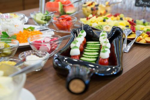 a table full of food with cucumbers and vegetables at Weingut Schreieck VINOTEL & GUTSHAUS in Sankt Martin