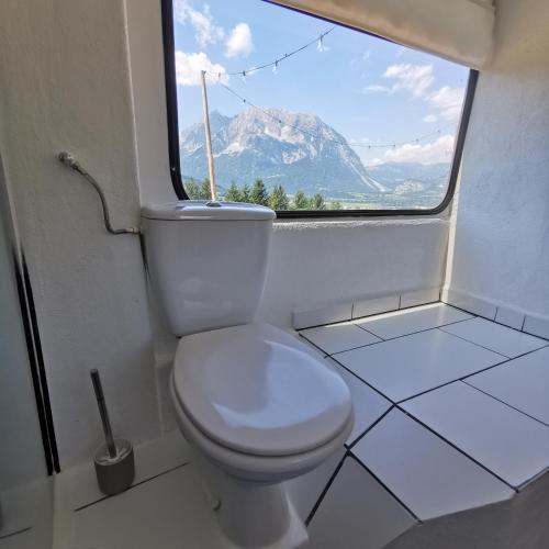 a bathroom with a toilet with a view of a mountain at Tiny House Feeling mit Weitblick in Irdning