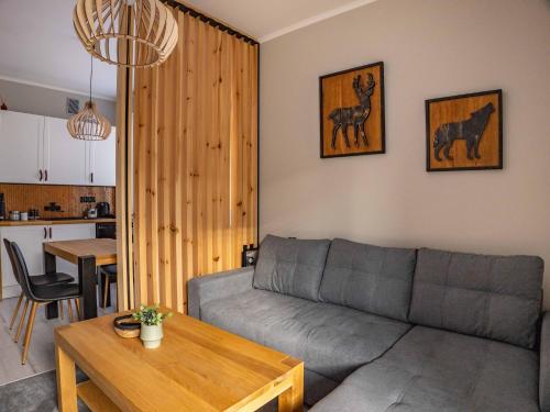 a living room with a couch and a table at Stylove Apartamenty in Ustrzyki Dolne