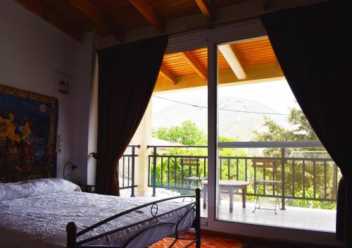 a bedroom with a bed and a large glass window at Ethia 2Floor Mountain View Cottage garden wifi ac in Ethiá